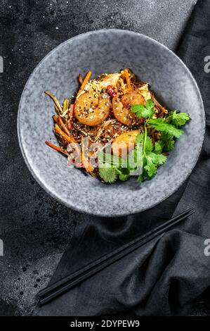 Singapore Mei Fun. Tagliatelle di riso con gamberi, gamberi, maiale al ciar siu, carota, cipolla, cavolo di nappa. Sfondo nero. Vista dall'alto Foto Stock