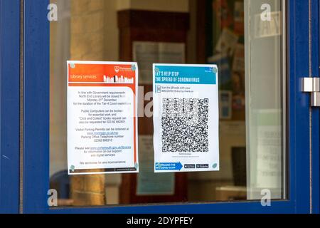 12-27-2020 Portsmouth, Hampshire, UK UN segnale di codice QR di traccia e di traccia NHS nella finestra di una biblioteca Foto Stock