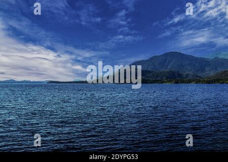 Le nuvole si radunano sulle montagne dietro il lago Kennedy. Il lago Kennedy si trova tra Port Alberni e Ucluelet sull'Isola di Vancouver, BC Foto Stock