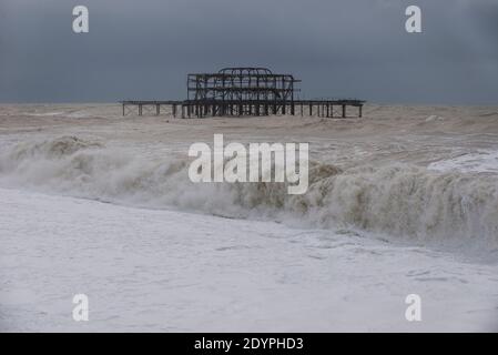 Brighton, Sussex orientale. 27 dicembre 2020. Regno Unito Meteo. I resti della tempesta Bella batte la costa sud con enormi onde che si infrangono sul lungomare di Brighton di fronte a spettatori audaci. L'Ufficio MET ha emesso avvertenze meteorologiche in tutto il Regno Unito a causa di forti venti e inondazioni. Credit: Francesca Moore/Alamy Live News Foto Stock