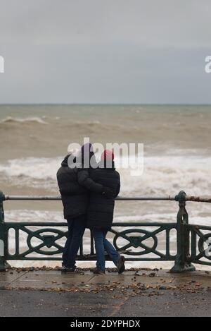 Brighton, Sussex orientale. 27 dicembre 2020. Regno Unito Meteo. I resti della tempesta Bella batte la costa sud con enormi onde che si infrangono sul lungomare di Brighton di fronte a spettatori audaci. L'Ufficio MET ha emesso avvertenze meteorologiche in tutto il Regno Unito a causa di forti venti e inondazioni. Credit: Francesca Moore/Alamy Live News Foto Stock