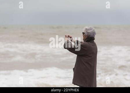 Brighton, Sussex orientale. 27 dicembre 2020. Regno Unito Meteo. I resti della tempesta Bella batte la costa sud con enormi onde che si infrangono sul lungomare di Brighton di fronte a spettatori audaci. L'Ufficio MET ha emesso avvertenze meteorologiche in tutto il Regno Unito a causa di forti venti e inondazioni. Credit: Francesca Moore/Alamy Live News Foto Stock