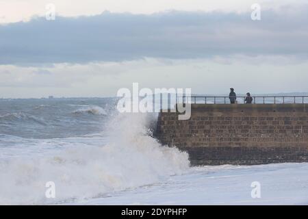 Brighton, Sussex orientale. 27 dicembre 2020. Regno Unito Meteo. I resti della tempesta Bella batte la costa sud con enormi onde che si infrangono sul lungomare di Brighton di fronte a spettatori audaci. L'Ufficio MET ha emesso avvertenze meteorologiche in tutto il Regno Unito a causa di forti venti e inondazioni. Credit: Francesca Moore/Alamy Live News Foto Stock