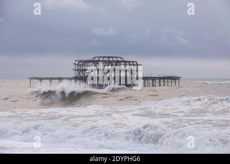 Brighton, Sussex orientale. 27 dicembre 2020. Regno Unito Meteo. I resti della tempesta Bella batte la costa sud con enormi onde che si infrangono sul lungomare di Brighton di fronte a spettatori audaci. L'Ufficio MET ha emesso avvertenze meteorologiche in tutto il Regno Unito a causa di forti venti e inondazioni. Credit: Francesca Moore/Alamy Live News Foto Stock