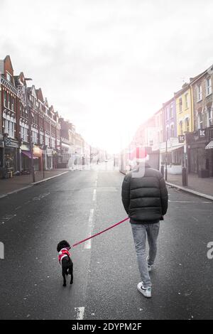 Camminando il cane che indossa un vestito di Babbo Natale in un High Street a Londra il giorno di Natale 2020 Foto Stock