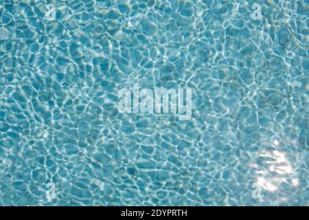 Piscina d'acqua con una texture caustica senza cuciture che splende il sole. Mosaico. Foto Stock