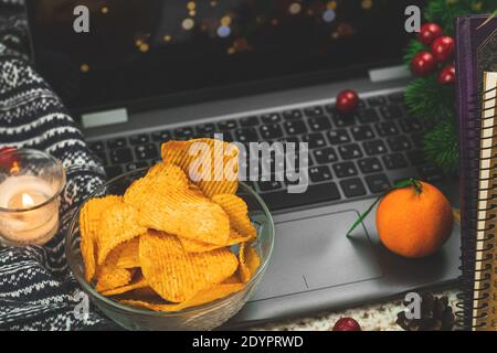 Notti calde d'inverno e d'autunno accoglienti con orologio cinematografico e cibo malsano, patatine in ciotola, maglia da vicino maglione Foto Stock