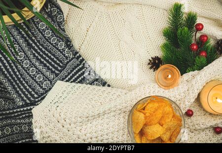Fiches di papato scanalati in ciotola trasparente su sfondo accogliente, maglione, decorazione invernale, composizione con spazio per la copia Foto Stock