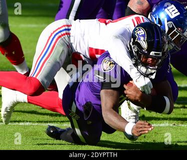 Baltimora, Stati Uniti. 27 Dicembre 2020. Il quarterback di Baltimora Ravens Lamar Jackson (8) è portato giù dalla sicurezza dei New York Giants Xavier McKinney (29) dopo un breve guadagno durante la prima metà all'M&T Bank Stadium di Baltimora, Maryland, domenica 27 dicembre 2020. Foto di David Tulis/UPI Credit: UPI/Alamy Live News Foto Stock