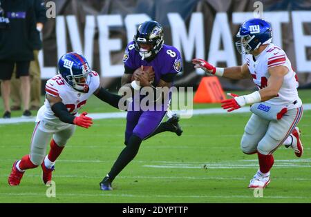 Baltimora, Stati Uniti. 27 Dicembre 2020. Il quarto di Baltimora Ravens Lamar Jackson (8) divide i difensori dei New York Giants Logan Ryan (23) e Blake Martinez (54) per la prima volta nel corso della prima metà all'M&T Bank Stadium di Baltimora, Maryland, domenica 27 dicembre 2020. Foto di David Tulis/UPI Credit: UPI/Alamy Live News Foto Stock