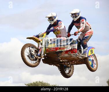 moto cross vestito con due piloti che volano attraverso l'aria in un salto Foto Stock