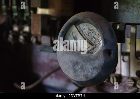 dettaglio di un vecchio amperometro con vetro rotto in vecchio impianto industriale Foto Stock