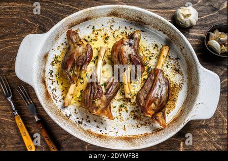 Agnello brasato fatto in casa in un piatto da forno. Sfondo di legno. Vista dall'alto Foto Stock