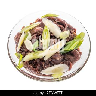Bulgogi di manzo con cipolla verde all'interno di una coppa di vetro A. Pasto sudcoreano su sfondo isolato Foto Stock