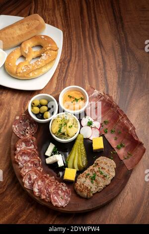 piatto di tapas a base di salumi tedeschi con carne e pane su sfondo tavola di legno Foto Stock