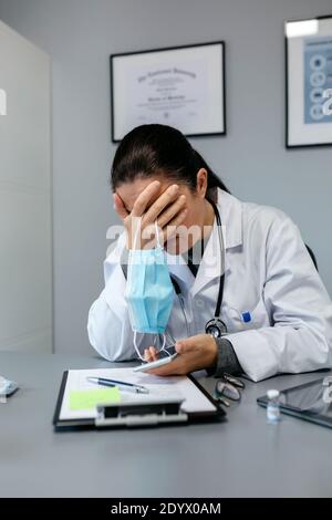 Preoccupata dottoressa con le mani sul viso Foto Stock