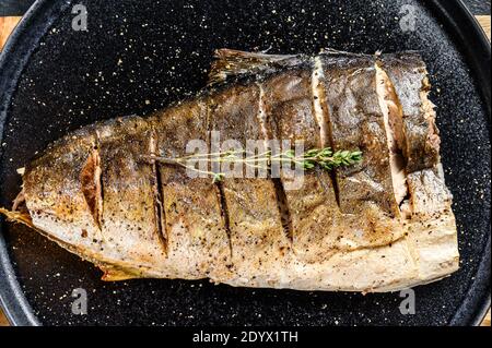 Yellowtail alla griglia, filetto di amberjack giapponese su un piatto. Sfondo nero. Vista dall'alto Foto Stock