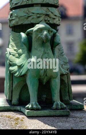 Immagine verticale di una scultura di aquila a Lubiana, Slovenia, sullo sfondo sfocato Foto Stock