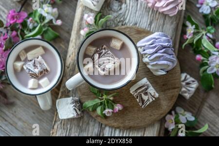 Vista dall'alto delle tazze di cacao con gustose marshmallows vicino alla primavera fiori Foto Stock
