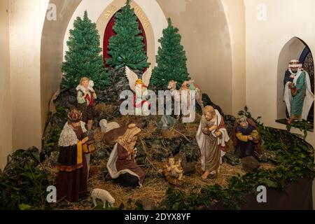 Campo cappella decorata con un presepe per le vacanze di Natale a venire. Le persone che passano qui si riferiscono alla religione e alla speranza Foto Stock