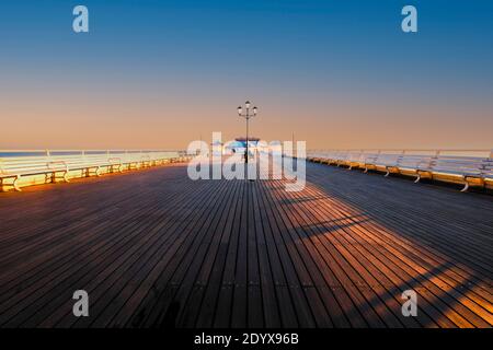 Vista lungo Cromer Pier a sunrise. Foto Stock