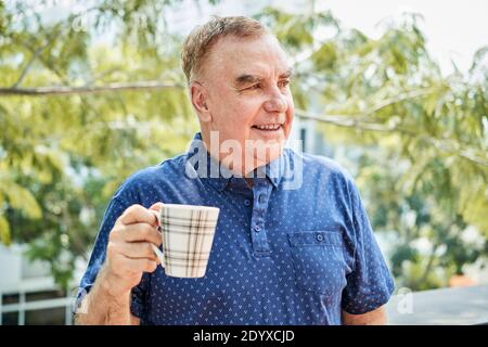 Uomo positivo con tazza di caffè Foto Stock