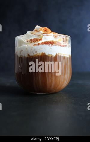 bevanda a base di caffè ghiacciato. Cappuccino o latte in un bicchiere trasparente su sfondo scuro Foto Stock