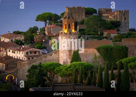 Vista sullo storico castello illuminato di Castiglione della Pescaia all'alba, Toscana, Italia Foto Stock