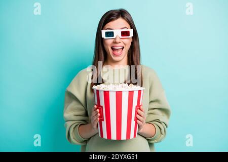 Ritratto fotografico di allegra urlante donna in 3D occhiali di tenuta benna per popcorn grande isolata su sfondo colorato di colore teal Foto Stock
