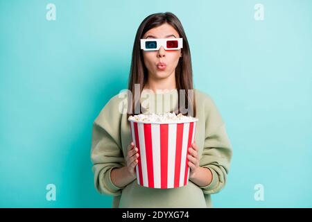 Ritratto fotografico di una donna scioccata che tiene in mano un grande secchio di popcorn due mani che indossano occhiali 3d isolati su un vivace colore ciano sfondo Foto Stock