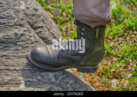 Stivali militari di protezione sulla roccia e cortile agricolo nel villaggio. 26.12.2020. Bursa. Turchia Foto Stock