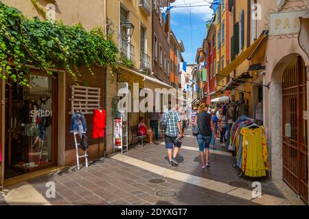 Vista di negozi e visitatori su una stradina in una giornata di sole, Garda, Lago di Garda, Provincia di Verona, Italia, Europa Foto Stock