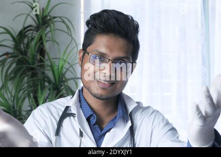 giovane medico asiatico che parla con la fotocamera in video chat. Foto Stock
