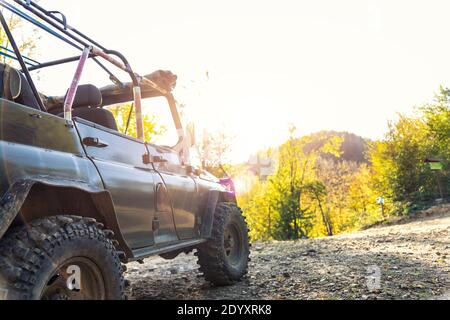 Vecchio veicolo retrò vintage 4x4 convertibile suv su sterrato ghiaia strada sterrata in estate al tramonto mattina sole. Avventura safari fuoristrada in montagna Foto Stock