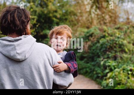 Non voglio andare ancora papà è ciò che questo il piccolo bambino sta pensando Foto Stock