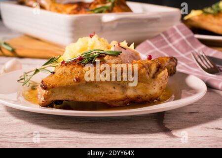 coscia di pollo su un piatto bianco con purè di patate una salsa al burro di rosmarino Foto Stock