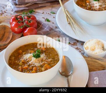 zuppa di lenticchie italiana su un tavolo di legno in una ciotola con pancetta e parmigiano Foto Stock