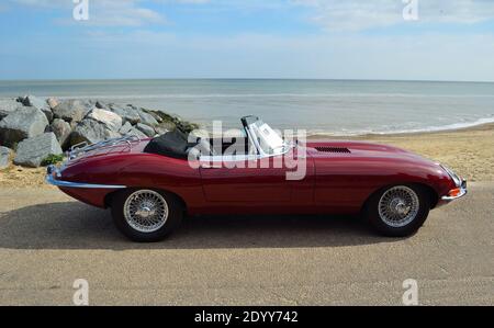 Auto a motore convertibile Classic Red Jaguar e Type parcheggiata sul lungomare. Foto Stock
