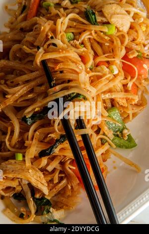 Pad kee mao altrimenti noto come noodles ubriachi è un Piatto di noodle thai speziato, fritto in padella con pollo a fette sottili Foto Stock