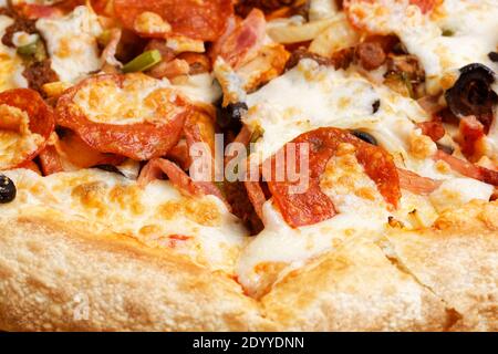 Chiocciolate la pizza con pepperoni, funghi, pancetta e olive. Messa a fuoco superficiale. Foto Stock