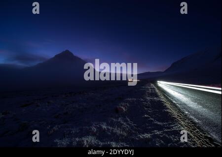 Glencoe, Scozia, Regno Unito. 28 Dic 2020. Nella foto: Buachaille Etive Mòr avvolta in un velo di nebbia mentre la temperatura scende nella notte. Glencoe sotto un tappeto di neve. Neve ancora adagiata sulle colline da notte neve caduta da Storm Bella. Temperature di congelamento con un avvertimento giallo ancora in vigore emesso dall'Ufficio MET. Credit: Colin Fisher/Alamy Live News Foto Stock