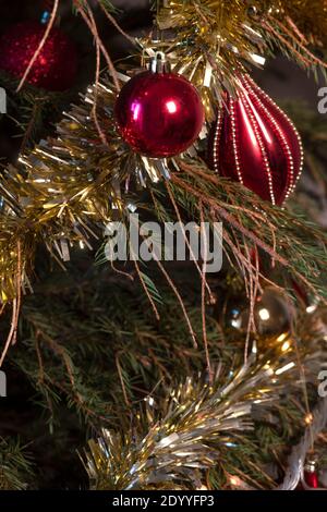 Immagine verticale dell'albero di Natale con aghi di pino caduto che si sparano dai rami con decorazioni. Copia spazio sullo sfondo Foto Stock