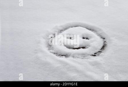 Un'emoji fatta nella neve su un tetto Foto Stock