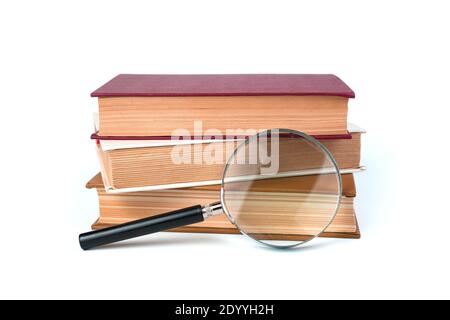 Tre libri e una lente di ingrandimento isolati su uno sfondo bianco. Foto Stock