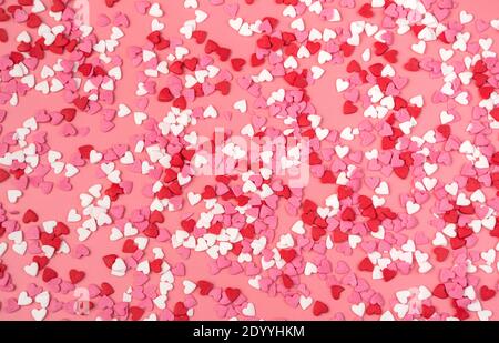 Un sacco di piccoli cuori su sfondo rosa. Vista dall'alto, sfondo romantico. Foto Stock