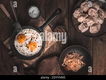 Pranzo su sfondo vintage con uova strapazzate, gnocchi e cavolo. Foto Stock