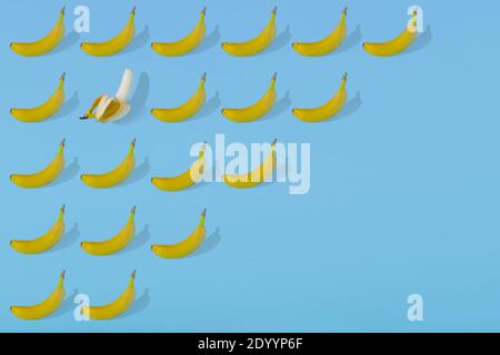 Modello estivo alla moda realizzato con frutta fresca di banana su sfondo azzurro luminoso. Concetto estivo minimo. Foto Stock