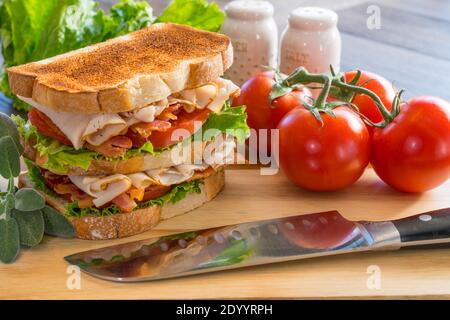 tacchino fresco sandwich club su pane tostato bianco su un legno tagliere Foto Stock