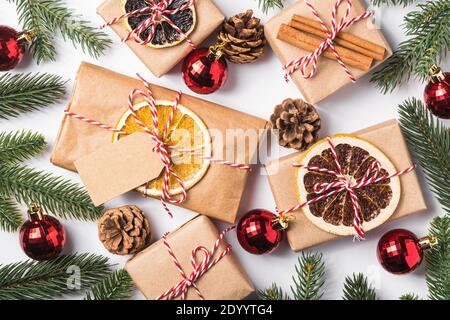 Vacanze di Natale zero rifiuti di carta regali che avvolgono con tag, baubles, frutta secca e rami di abete Foto Stock