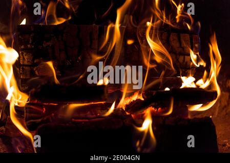 Fiamme nel camino. Closeup di legno in fiamme. Calore da legno e carbone. Foto Stock